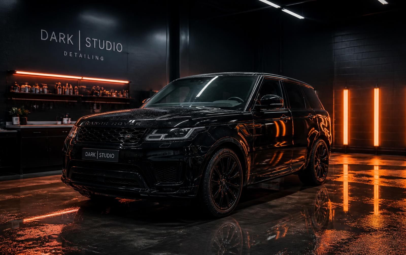 Freshly detailed black SUV with a glossy ceramic-coated finish inside a detailing studio